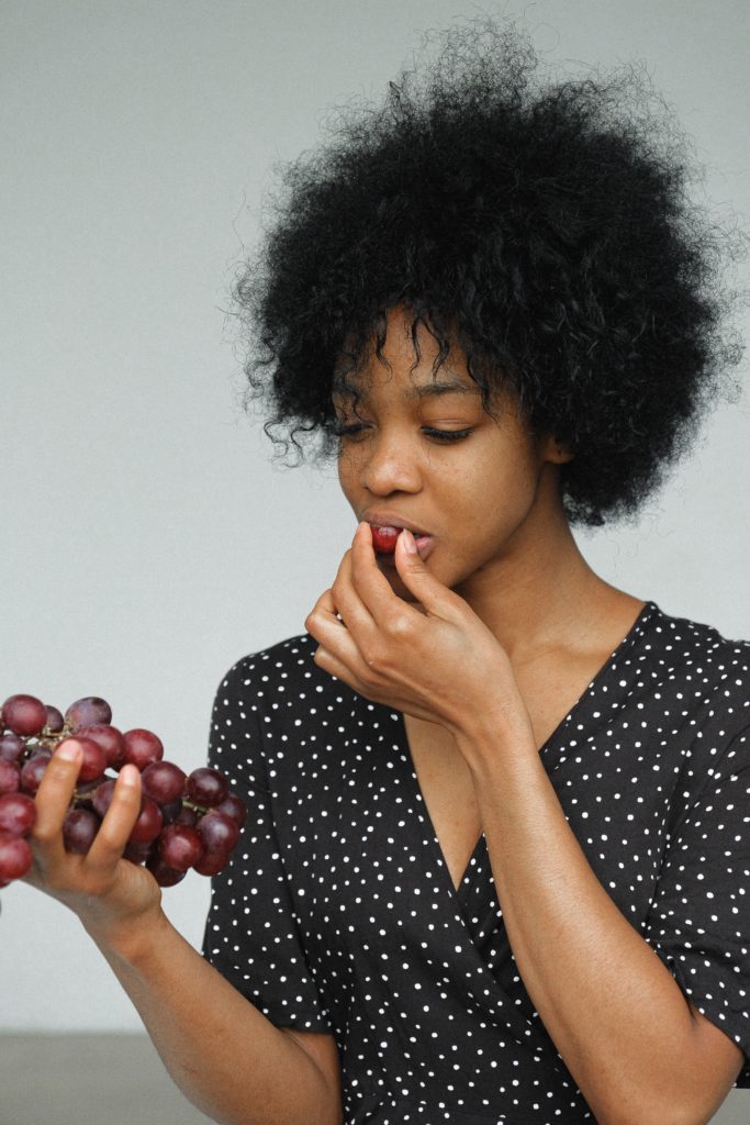 אישה אוכלת ענבים אדומים