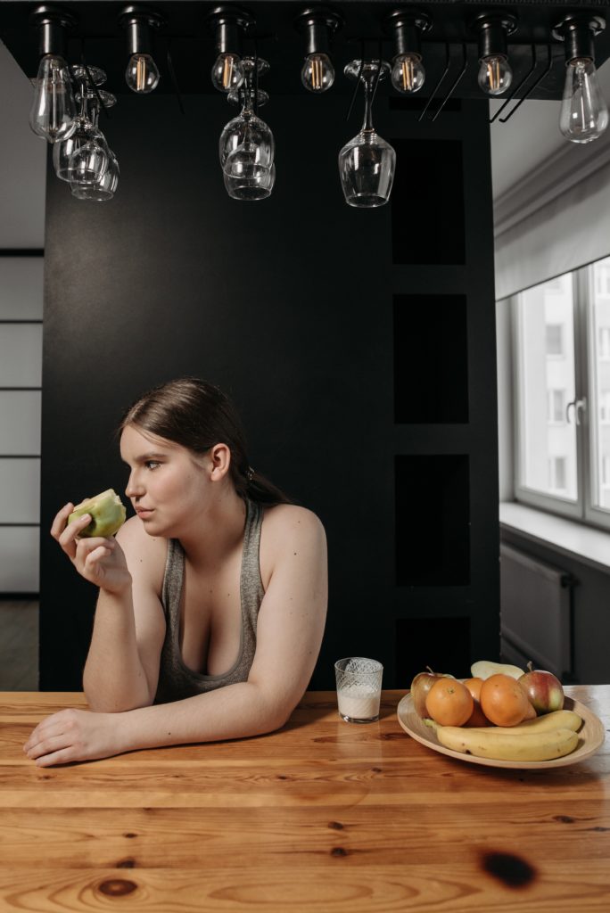 בחורה אוכלת תפוח במטבח